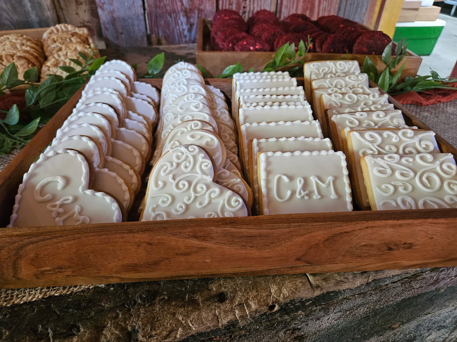 Monogrammed white wedding cookies in wooden trays