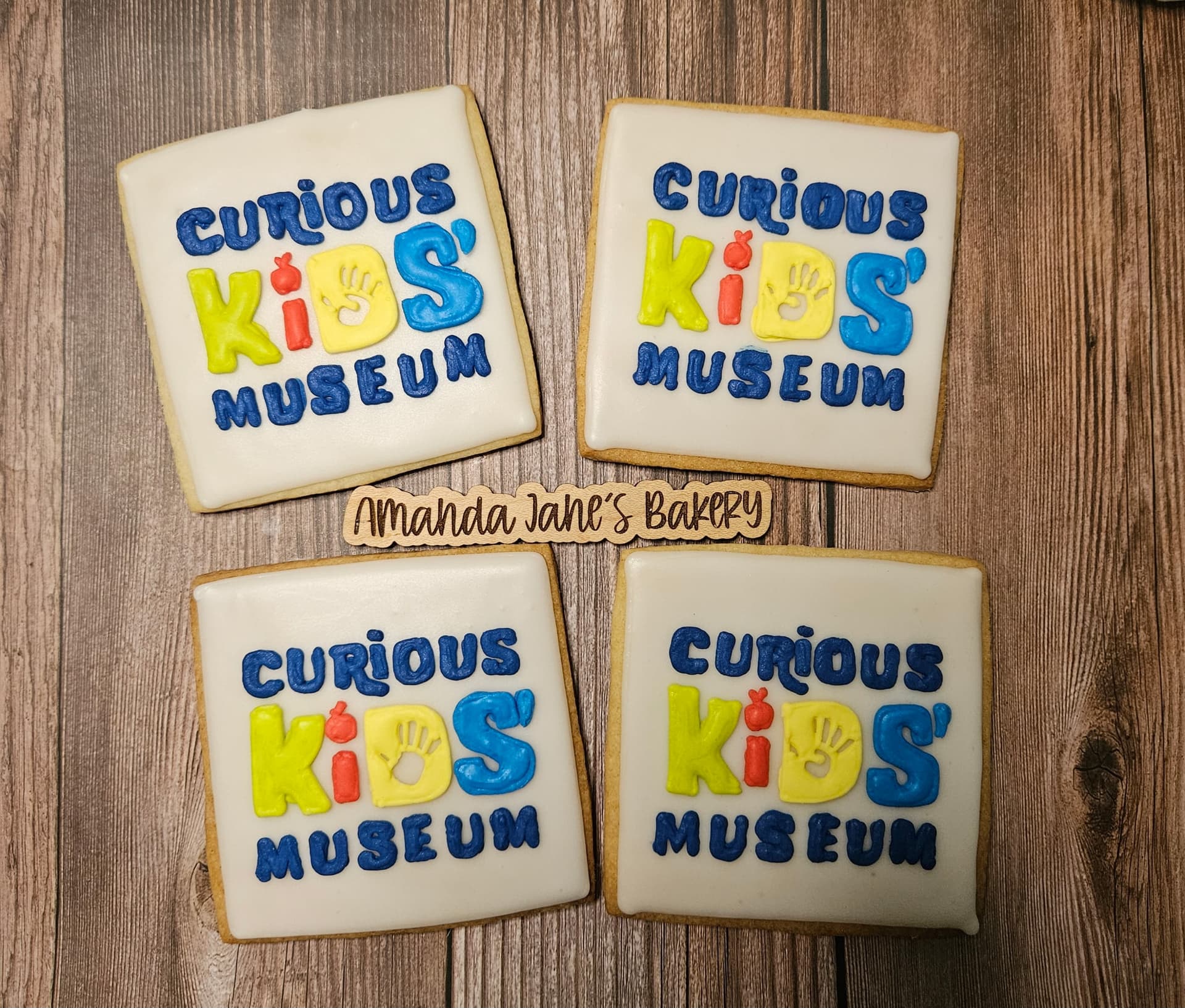 Hand-piped Curious Kids Museum logo cookies for a corporate order